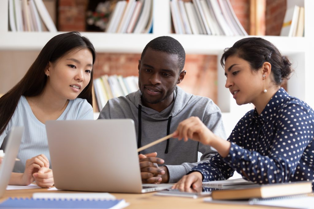 Students looking at a computer and discussing ideas.