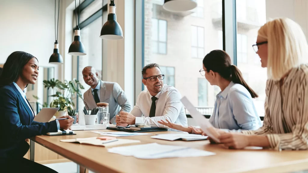 Business people around a table talking about how they'll use SimVenture Validate to develop a workplace training programme.