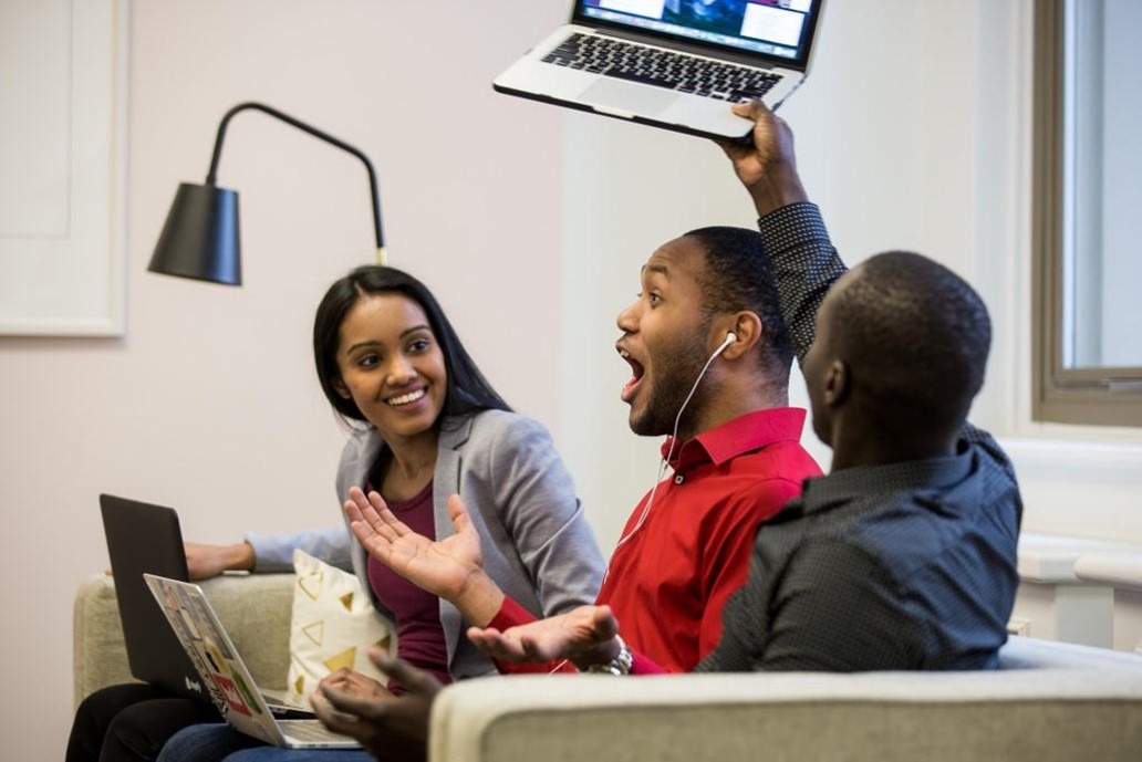 Three university students celebrating their success using SimVenture software