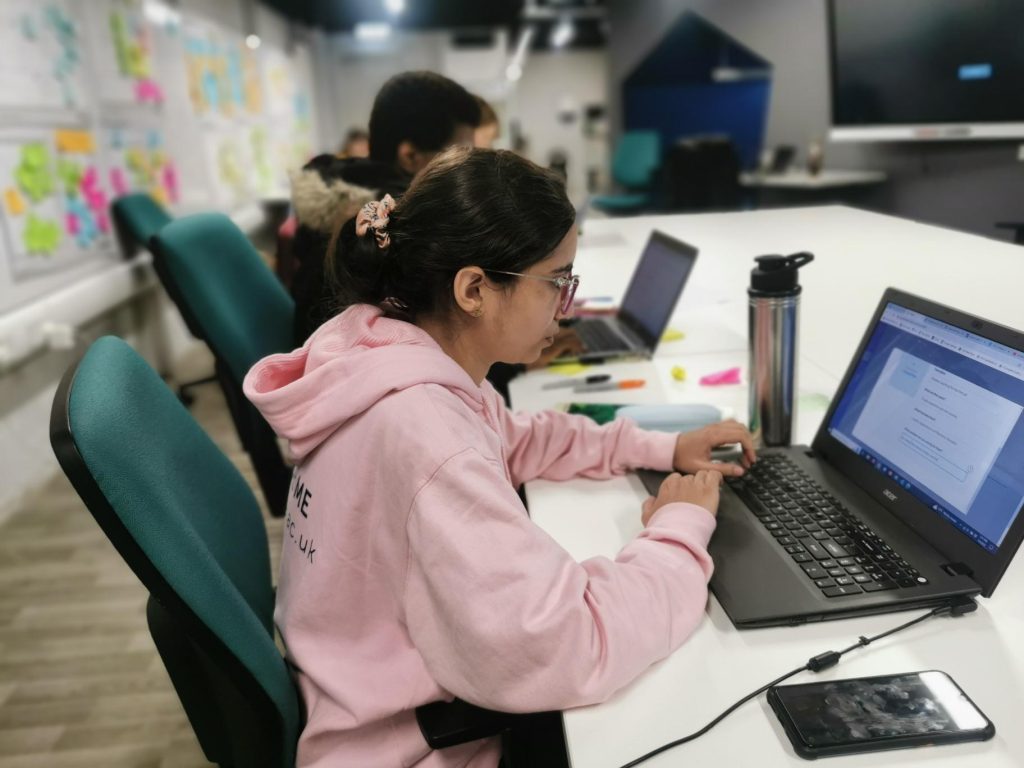 Learner using Validate on her laptop in a startup hub to develop a business idea.