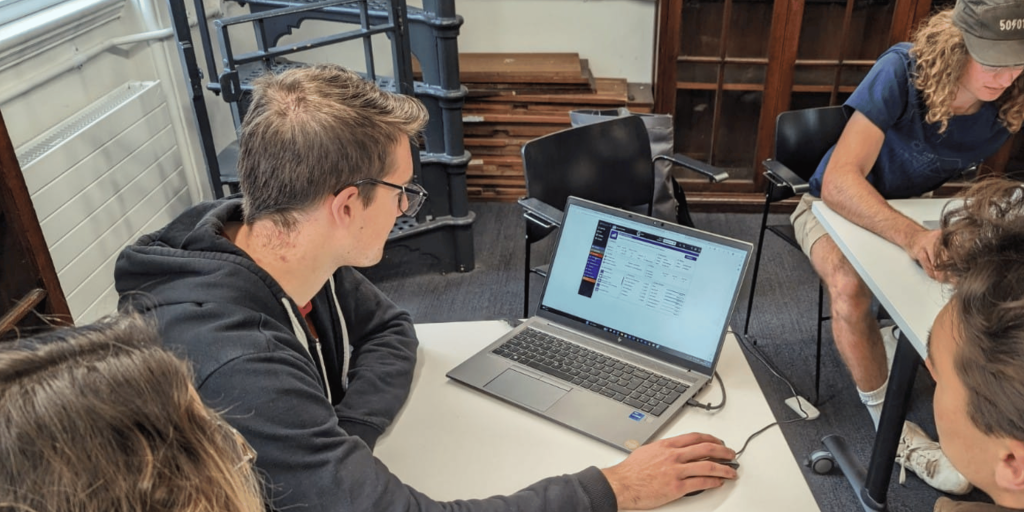 Hands-on learning with a business simulation. Here three Oxford University students sit around a laptop deciding their next move in the online business simulation game, Evolution.