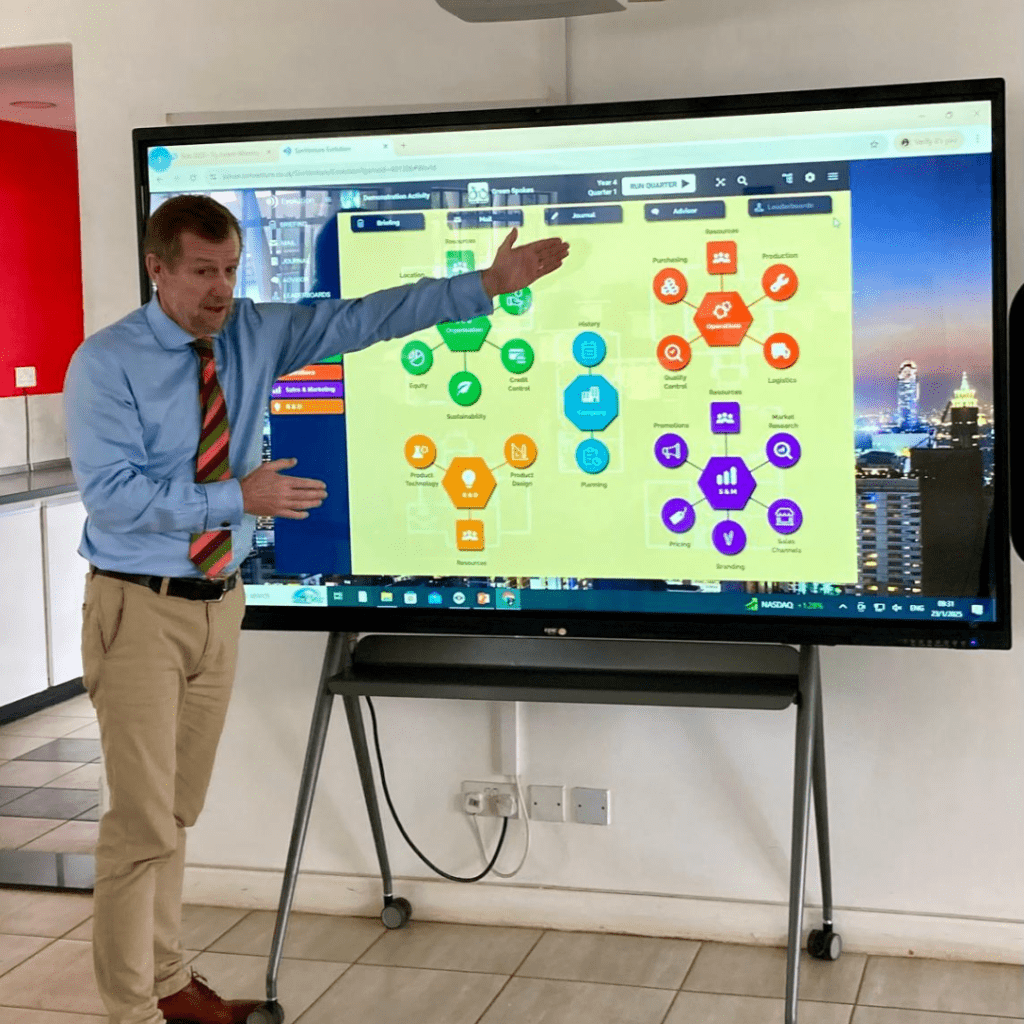 Mark Barber, Schools Development Manager at SimVenture, introducing our business simulation, Evolution, on a large screen to students.